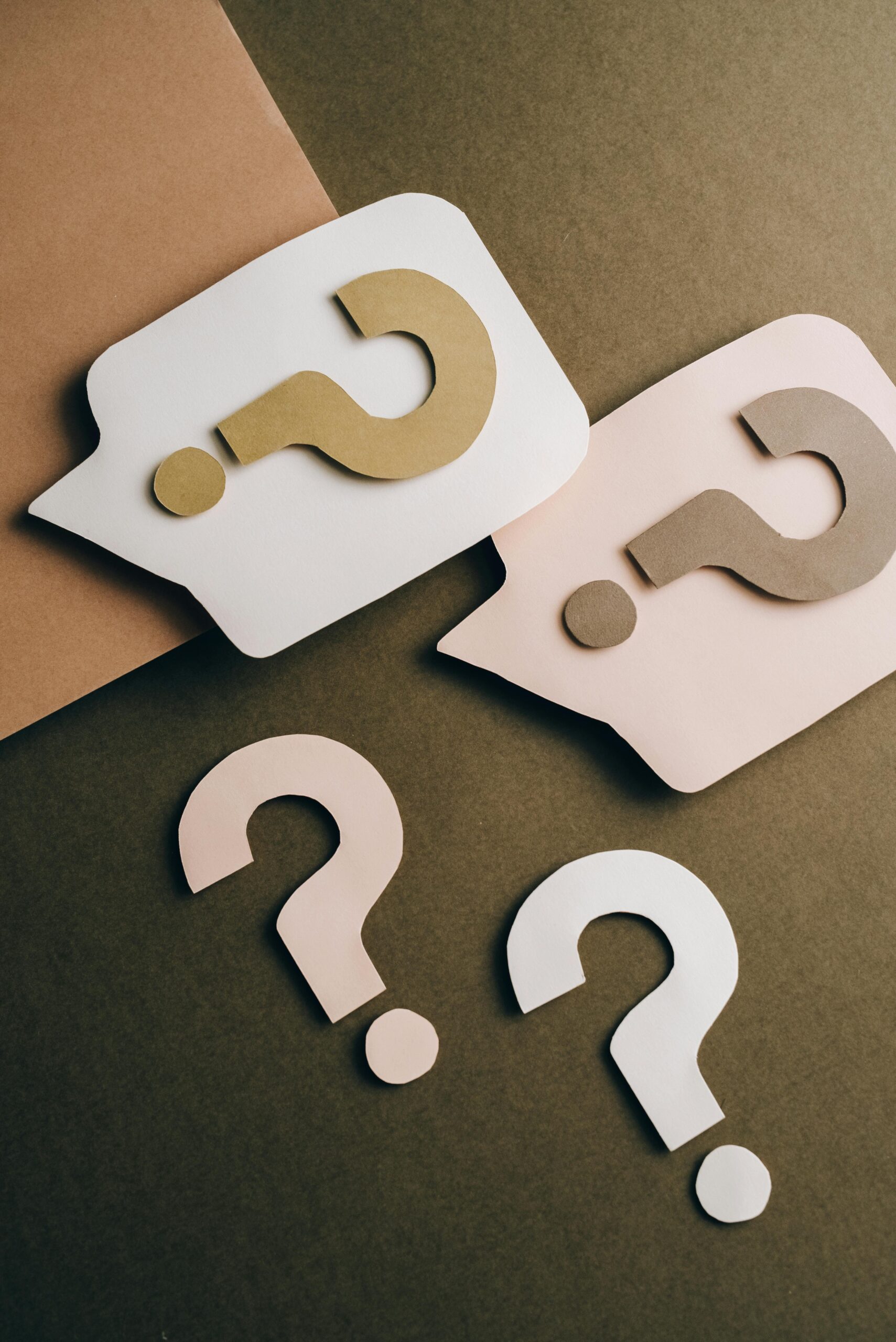 pexels-photo-5428835-5428835-1 Artistic paper cutouts of question marks creating a conceptual design on a brown surface.